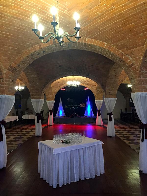 Vaulted brick room with a dance floor and chandelier