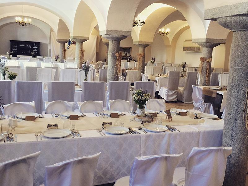 Sala z kolumnami i białymi krzesłami nakryta na przyjęcie
