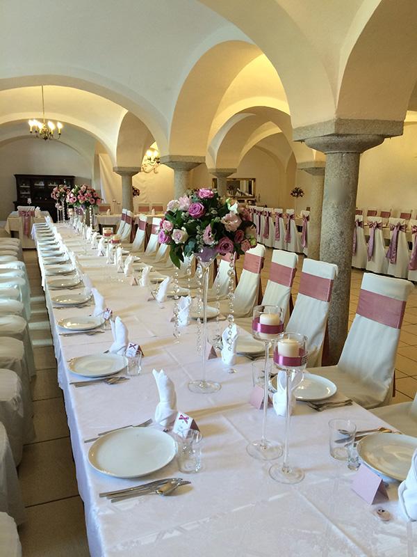 Long white wedding table beneath a groin vault