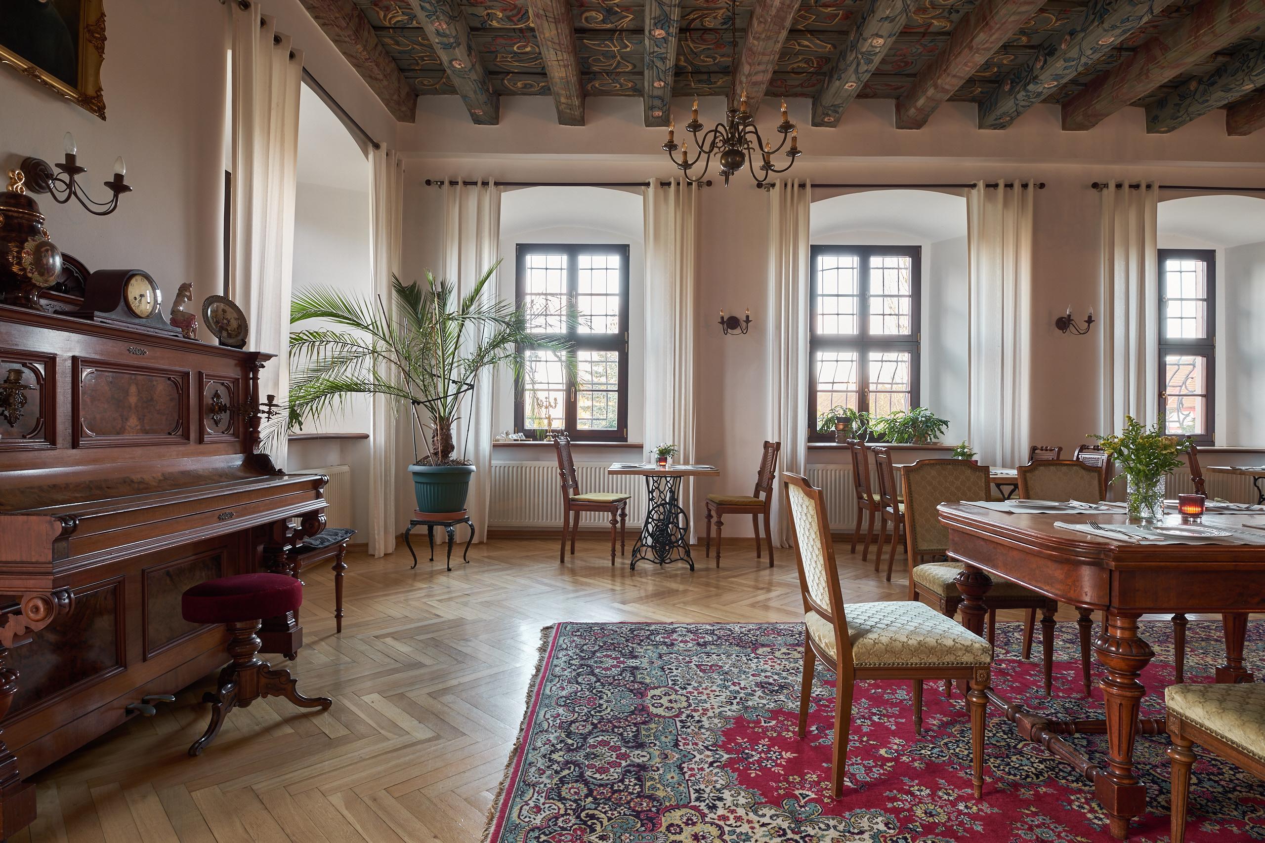 Palace salon with a beamed ceiling, tables and antique furniture