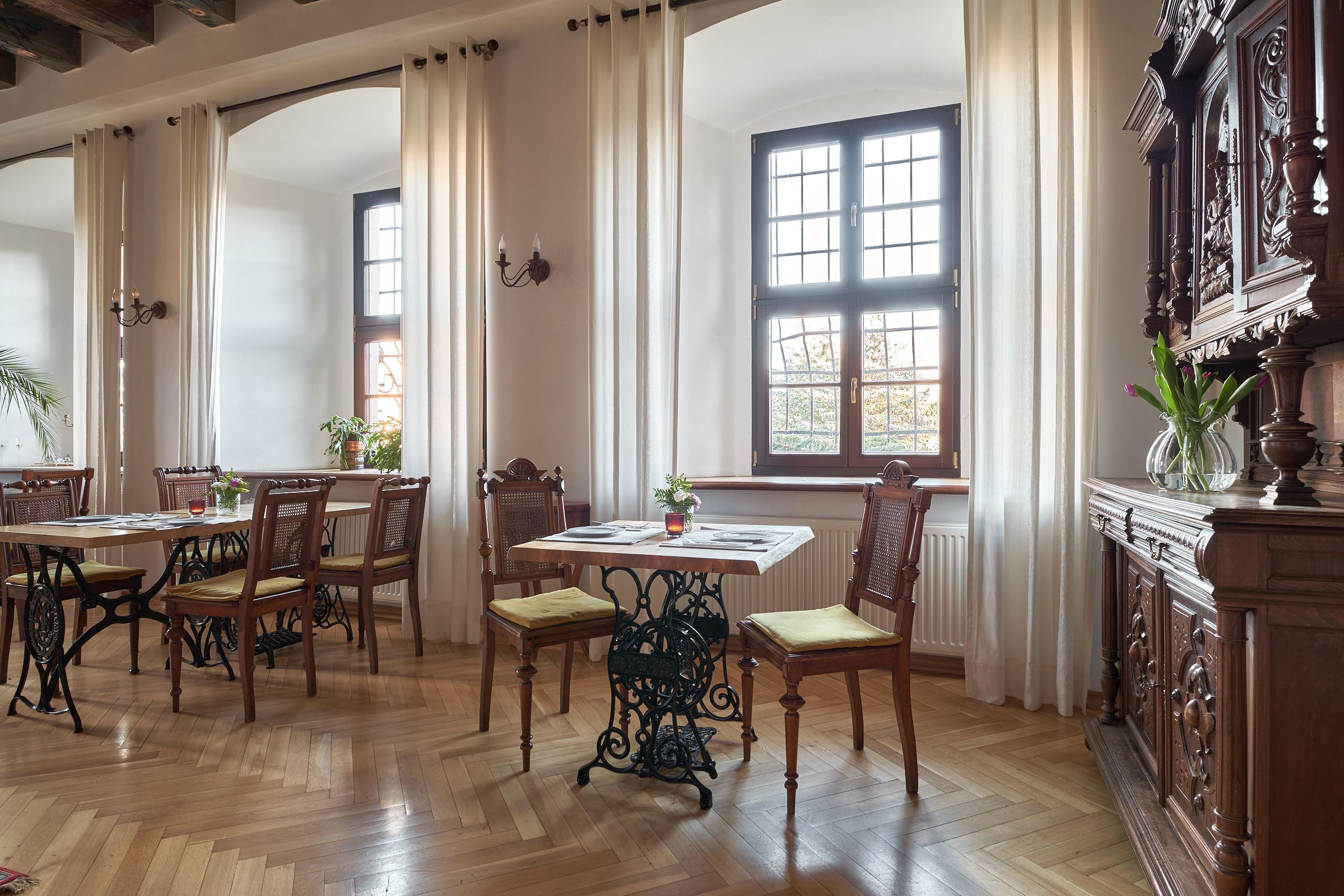 Bright room with laid tables and a carved sideboard